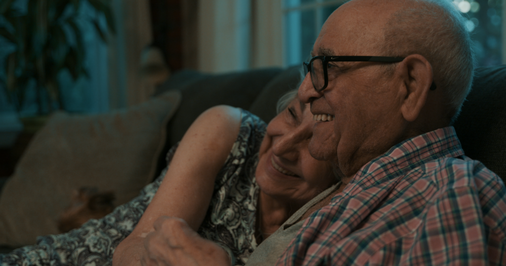 A Man and a woman sit closely on a couch